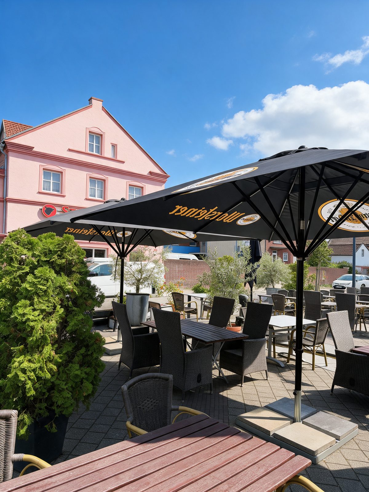 Sonnige Terrasse mit Schirmen und gedeckten Tischen